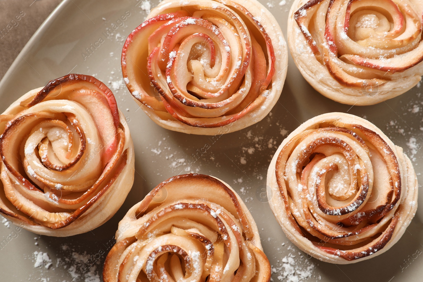 Photo of Freshly baked apple roses on plate. top view. Beautiful dessert