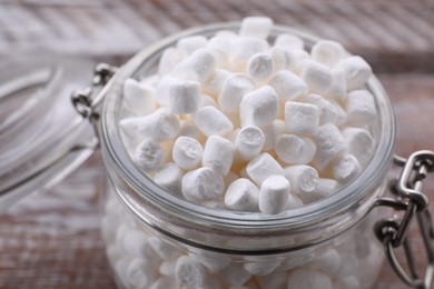 Glass jar with delicious marshmallows on wooden table, closeup