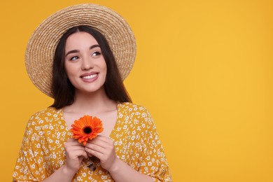 Photo of Beautiful woman with spring flower in hands on yellow background, space for text