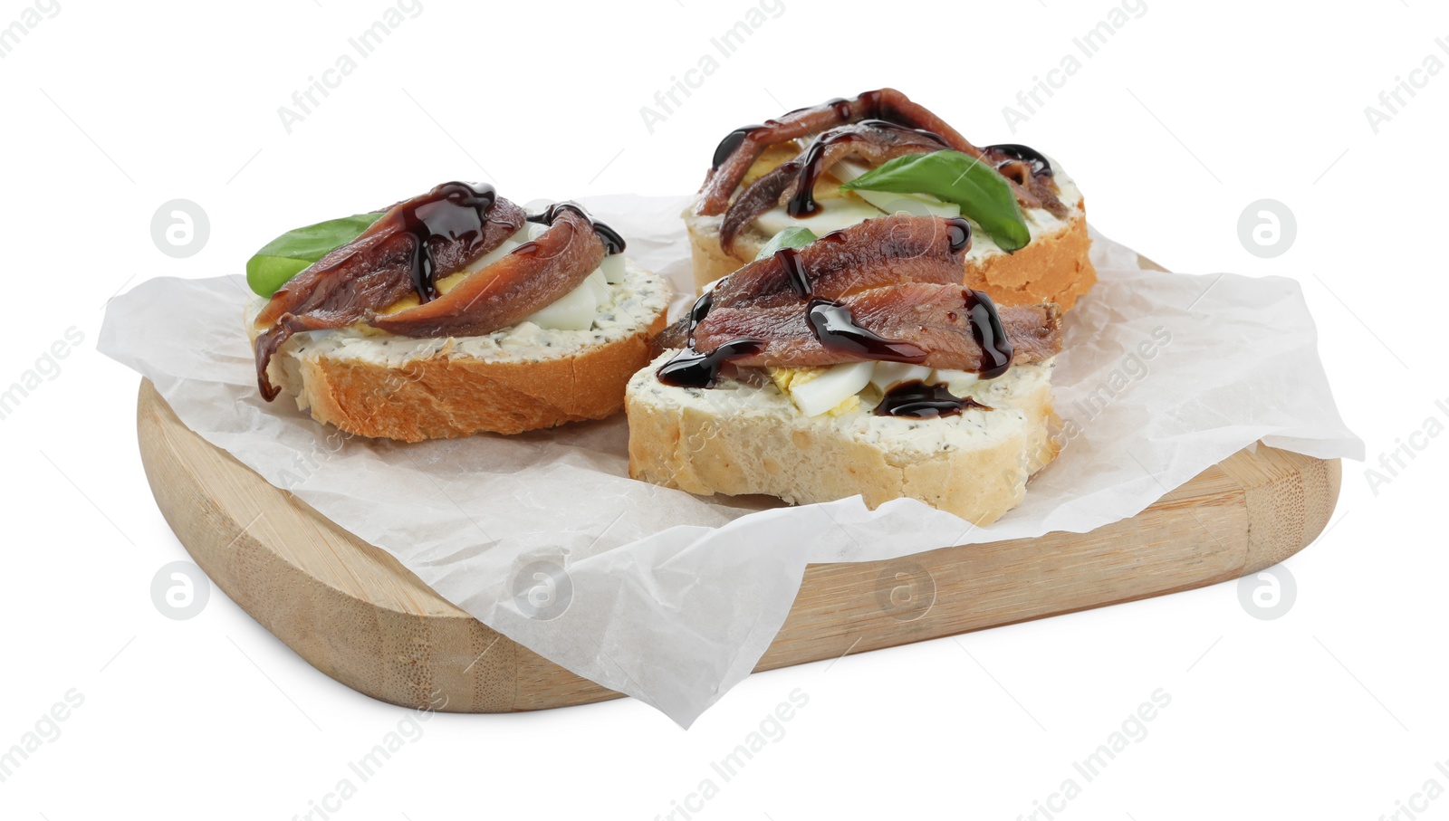 Photo of Delicious bruschettas with anchovies, eggs, basil and sauce on white background