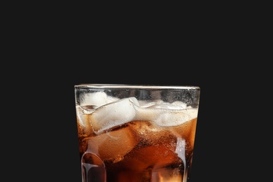 Photo of Glass of tasty refreshing cola with ice cubes on black background, closeup