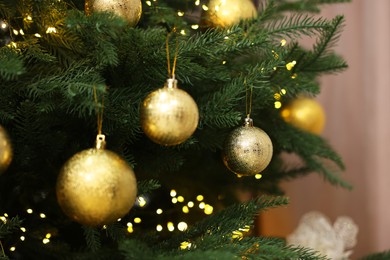 Photo of Beautiful Christmas balls hanging on fir tree, closeup