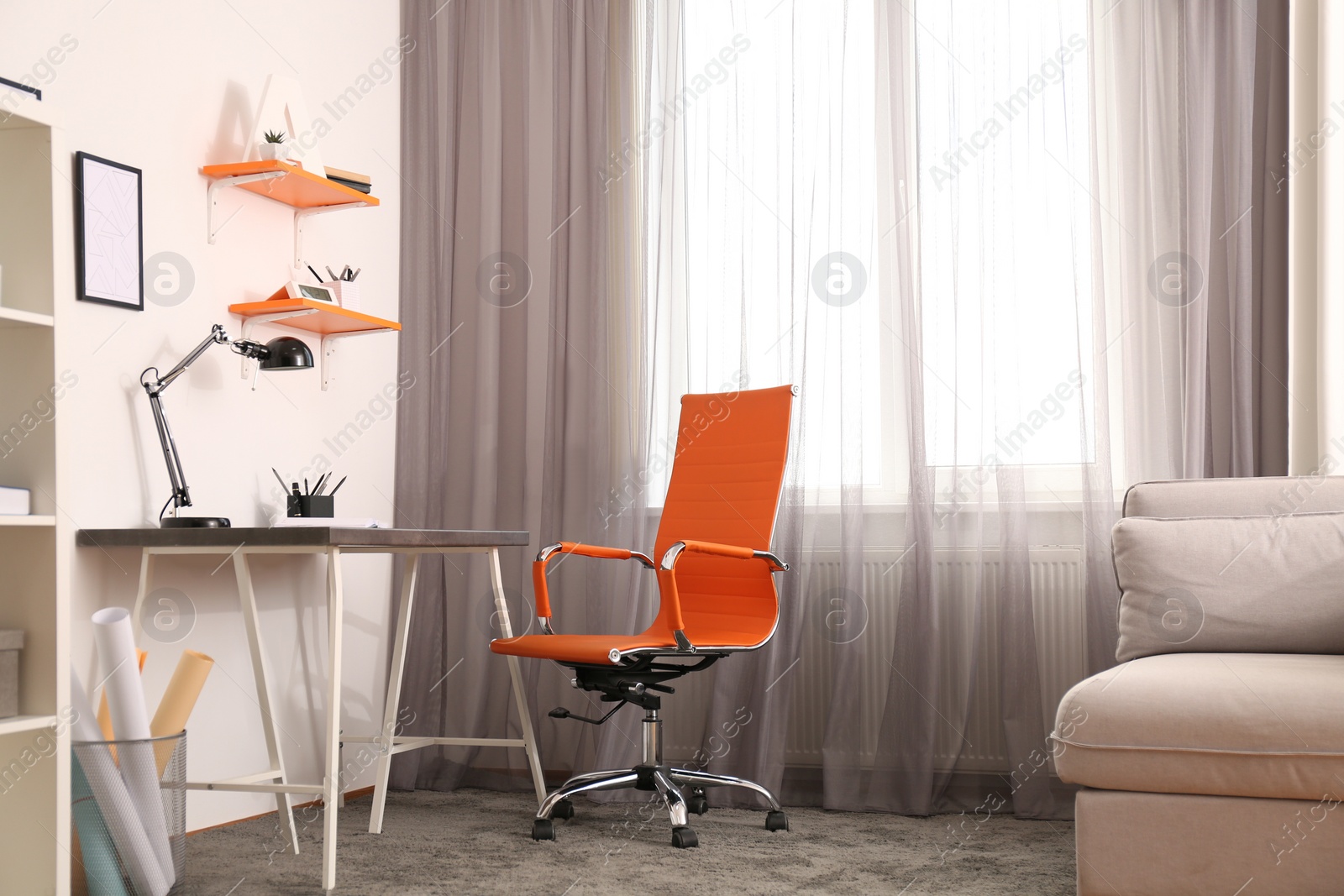 Photo of Stylish room interior with comfortable workplace near window. Design idea
