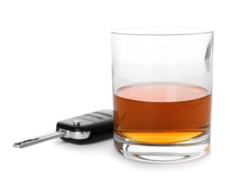 Photo of Glass of alcohol and car key on white background. Responsible driving concept