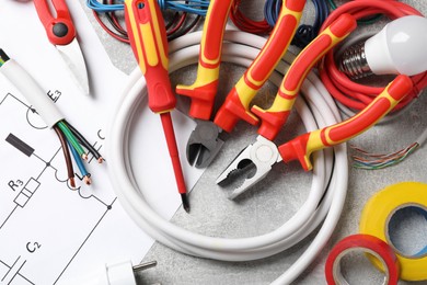 Set of electrician's tools and accessories on grey background