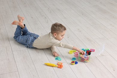 Photo of Cute little boy playing on warm floor indoors, space for text. Heating system