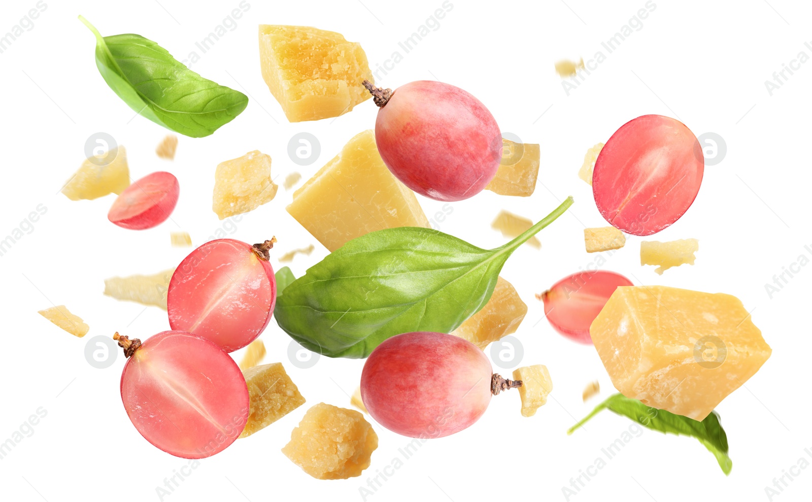 Image of Pieces of delicious parmesan, grapes and basil leaves falling on white background