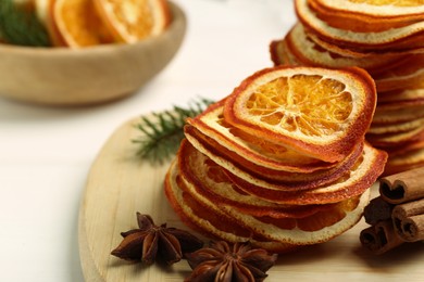 Photo of Dry orange slices., anise stars and cinnamon sticks on white table, closeup. Space for text
