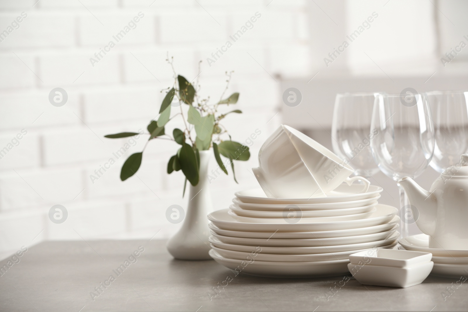 Photo of Set of clean dishes on table against blurred background. Space for text