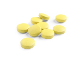 Many yellow pills isolated on white. Medicinal treatment