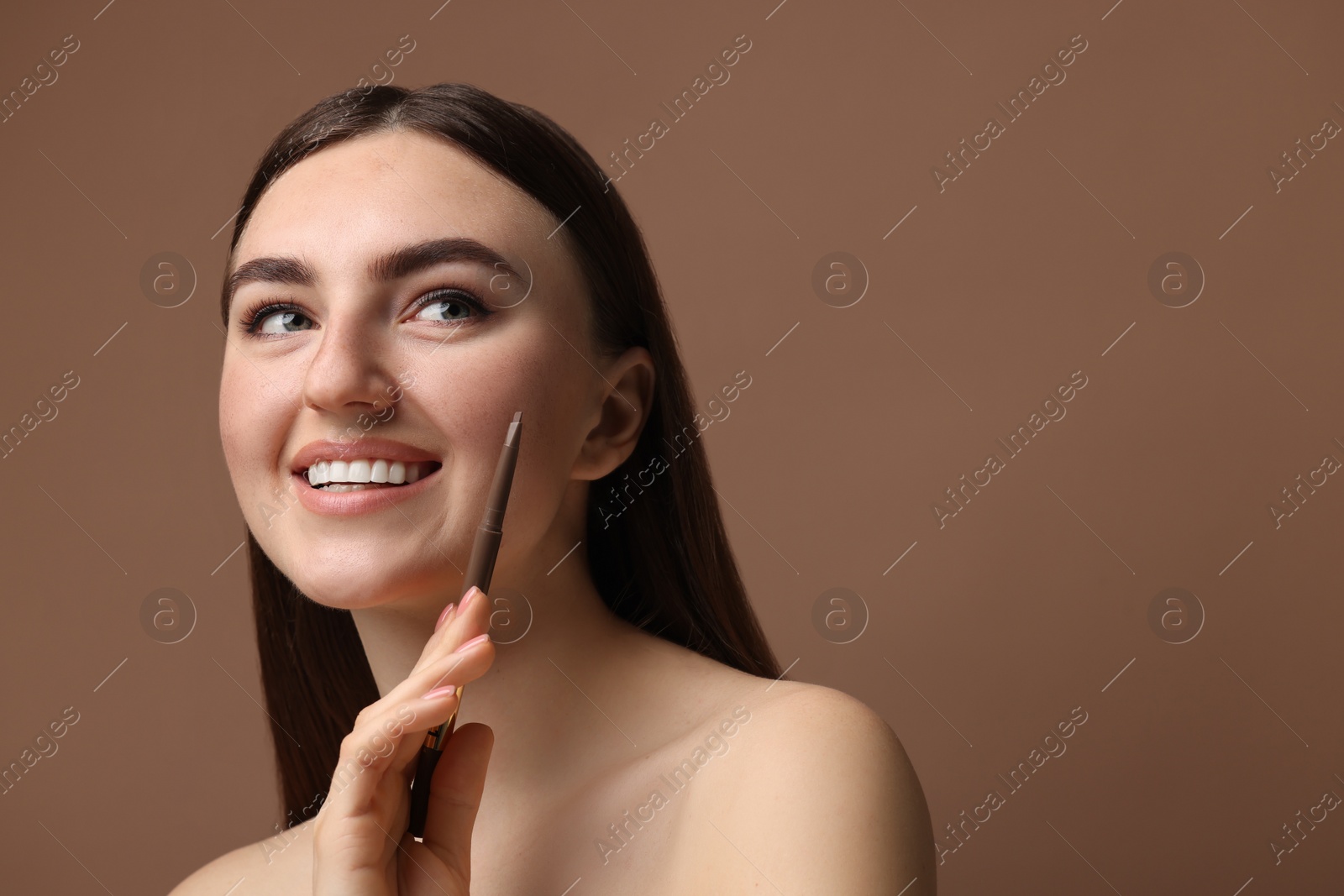 Photo of Happy woman with freckle pen on brown background. Space for text