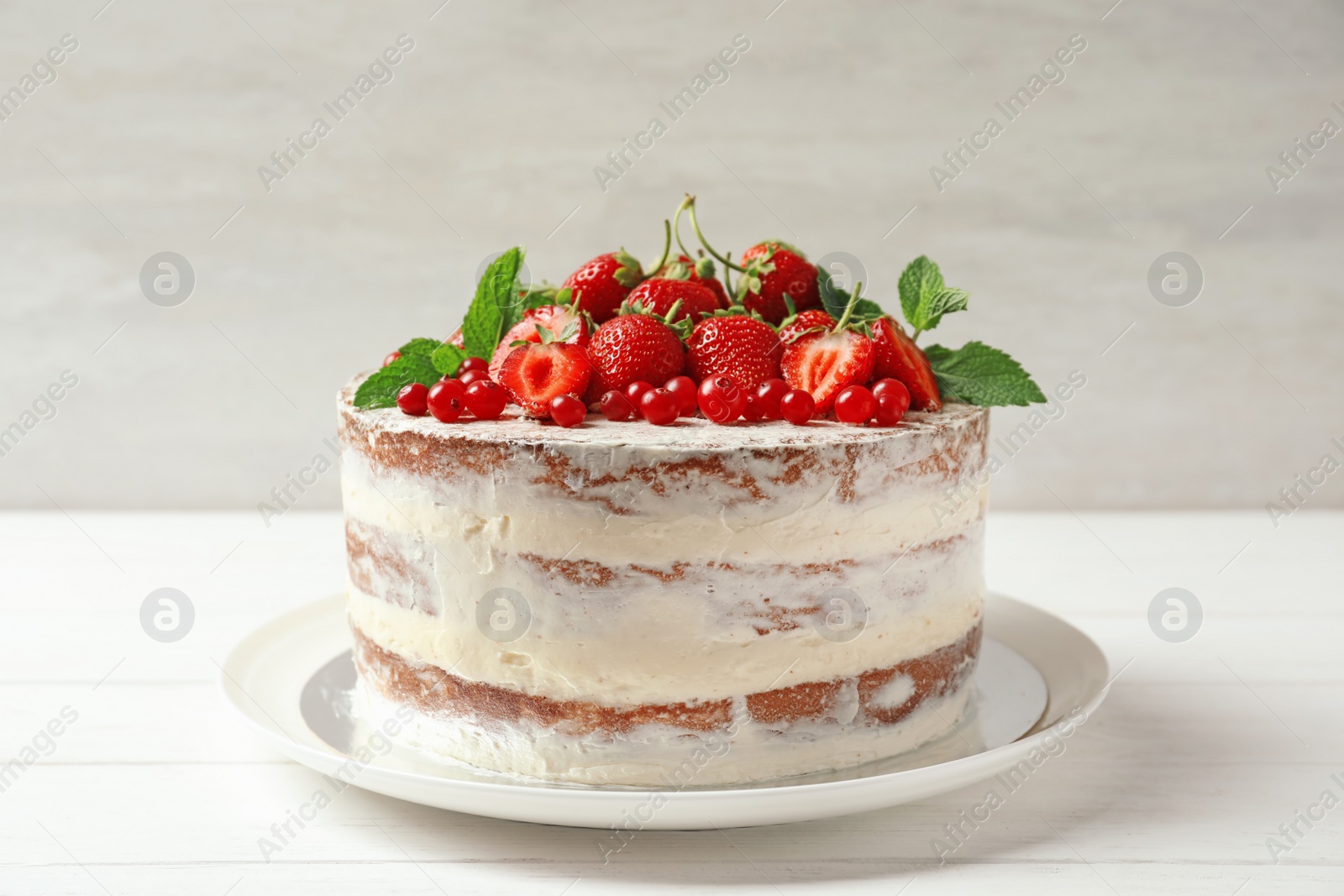 Photo of Delicious homemade cake with fresh berries on wooden table