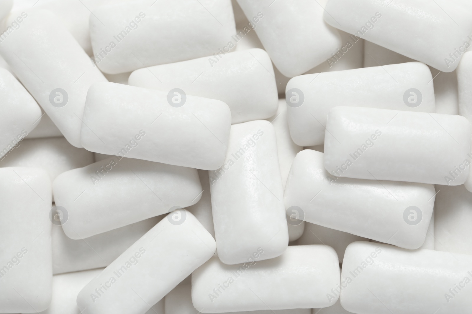 Photo of Tasty white chewing gums as background, top view