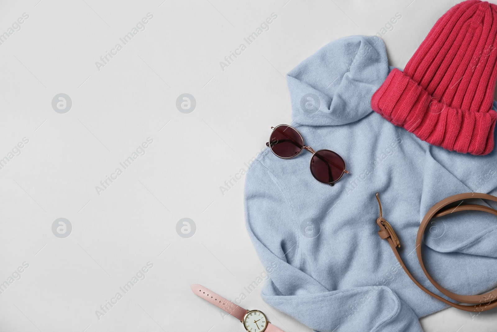 Photo of Stylish look with cashmere sweater, flat lay. Women's clothes and accessories on fabric