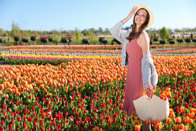 Woman in beautiful tulip field on sunny day