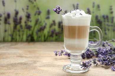 Delicious latte with lavender on wooden table. Space for text