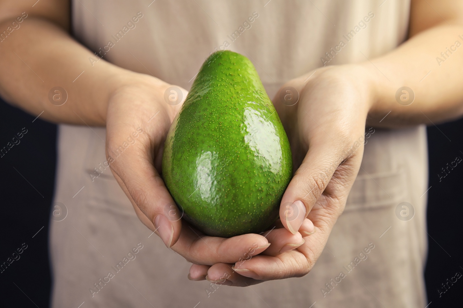 Photo of Woman holding ripe fresh avocado, closeup