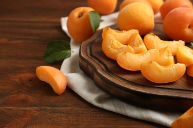 Photo of Composition with delicious ripe sweet apricots on wooden table, space for text