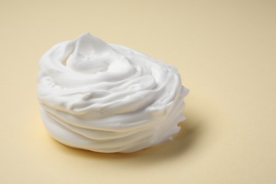 Photo of Sample of shaving foam on beige background, closeup. Space for text