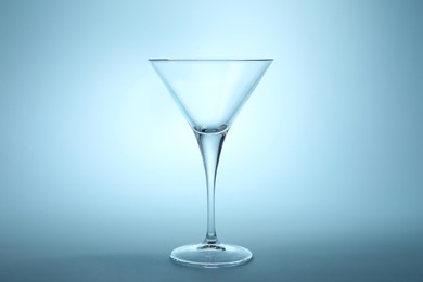 Elegant empty martini glass on light blue background