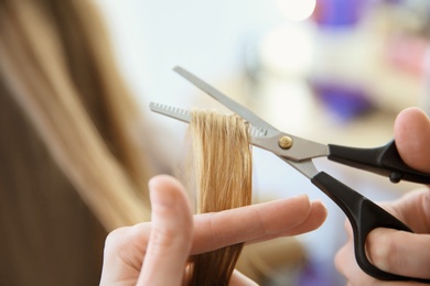 Photo of Professional hairdresser working with client in salon