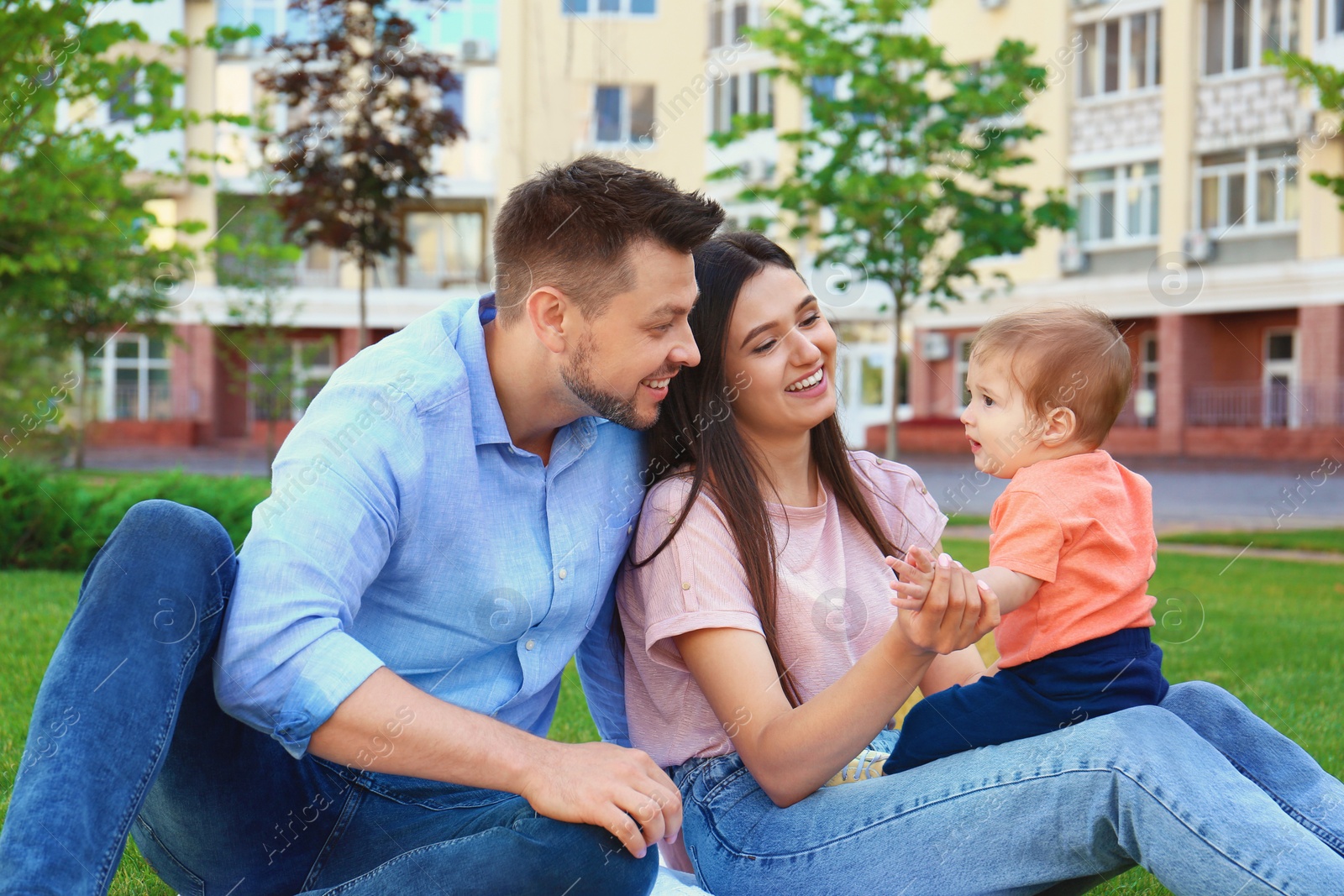 Photo of Happy family with adorable little baby outdoors