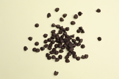 Photo of Pile of delicious chocolate chips on beige background, top view