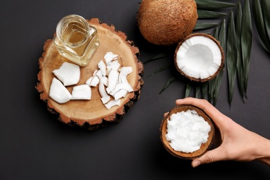 Young woman with coconut oil on grey background, closeup