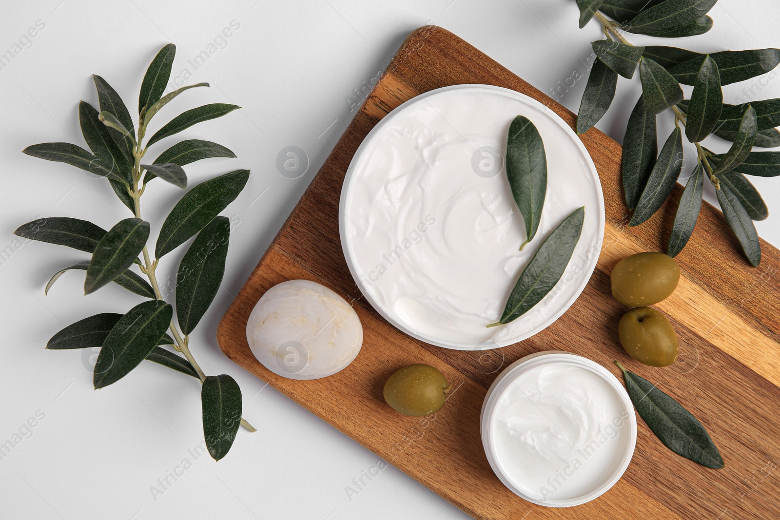 Photo of Flat lay composition with jars of cream and olives on white background