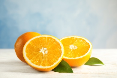 Fresh oranges with leaves on wooden table