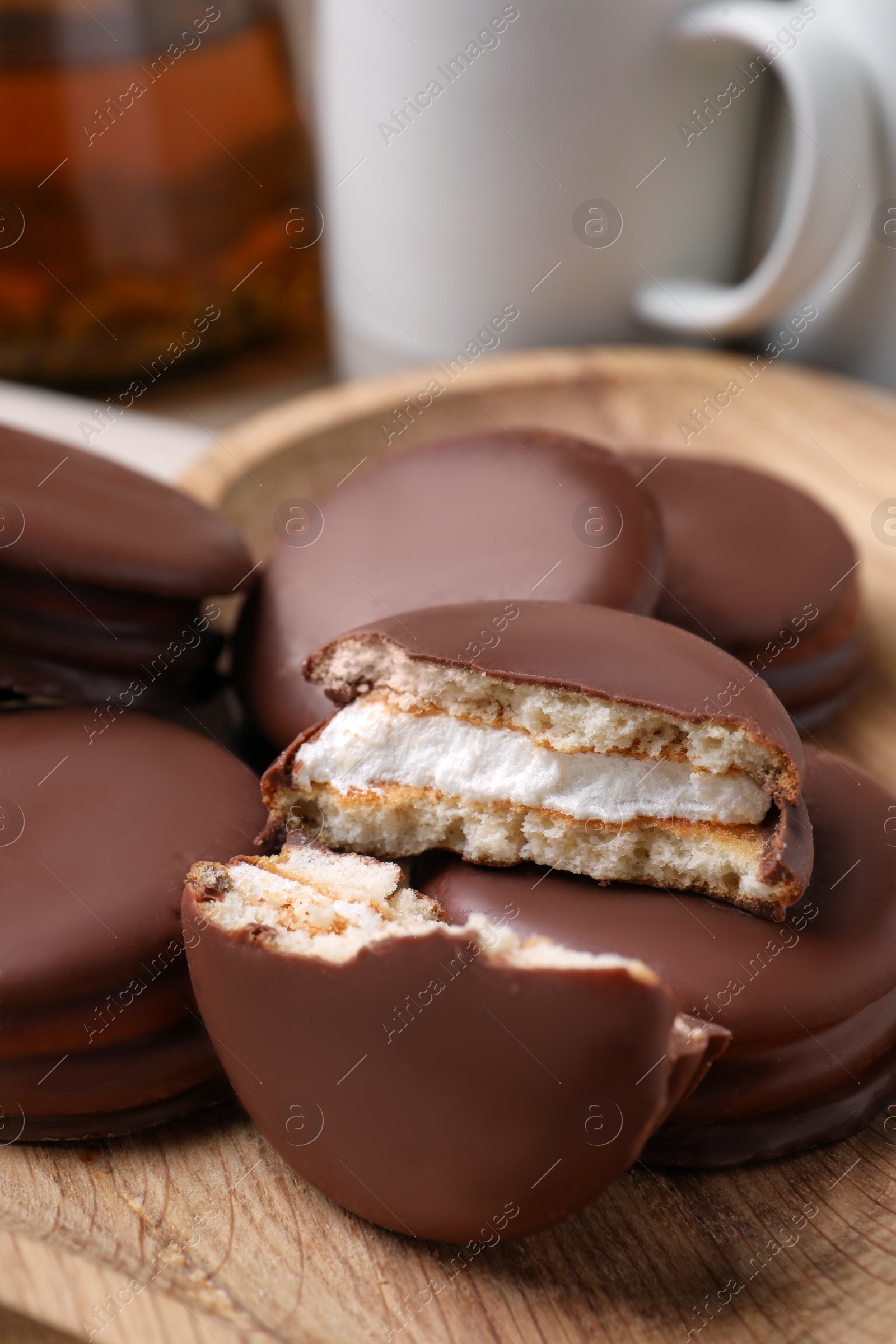Photo of Tasty choco pies on wooden plate, closeup view