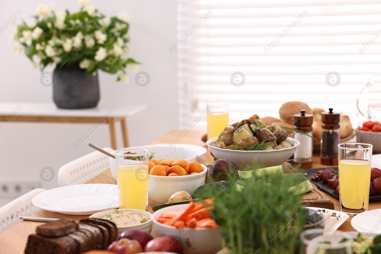 Photo of Healthy vegetarian food and glasses of juice on table indoors