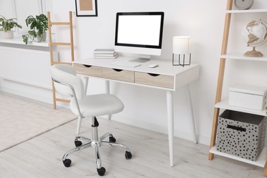 Photo of Workplace with comfortable office chair indoors. Interior design