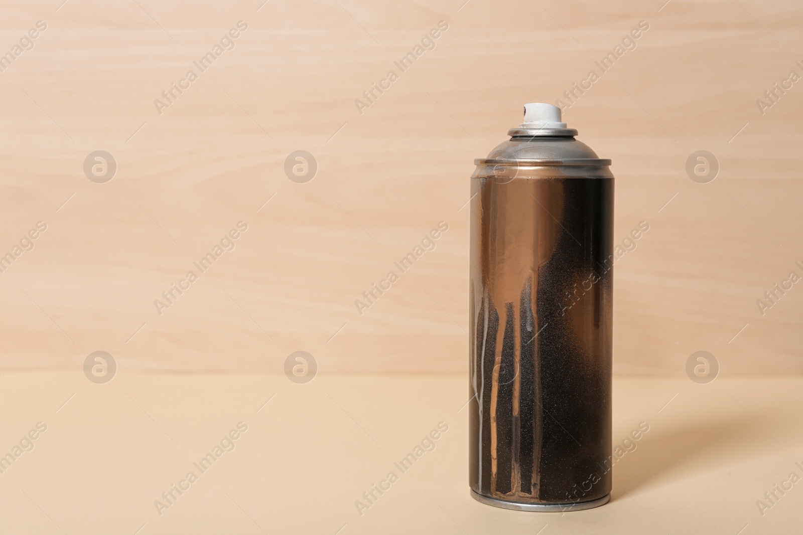 Photo of Used can of spray paint on wooden background. Space for text