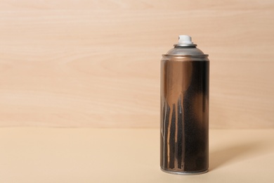 Photo of Used can of spray paint on wooden background. Space for text