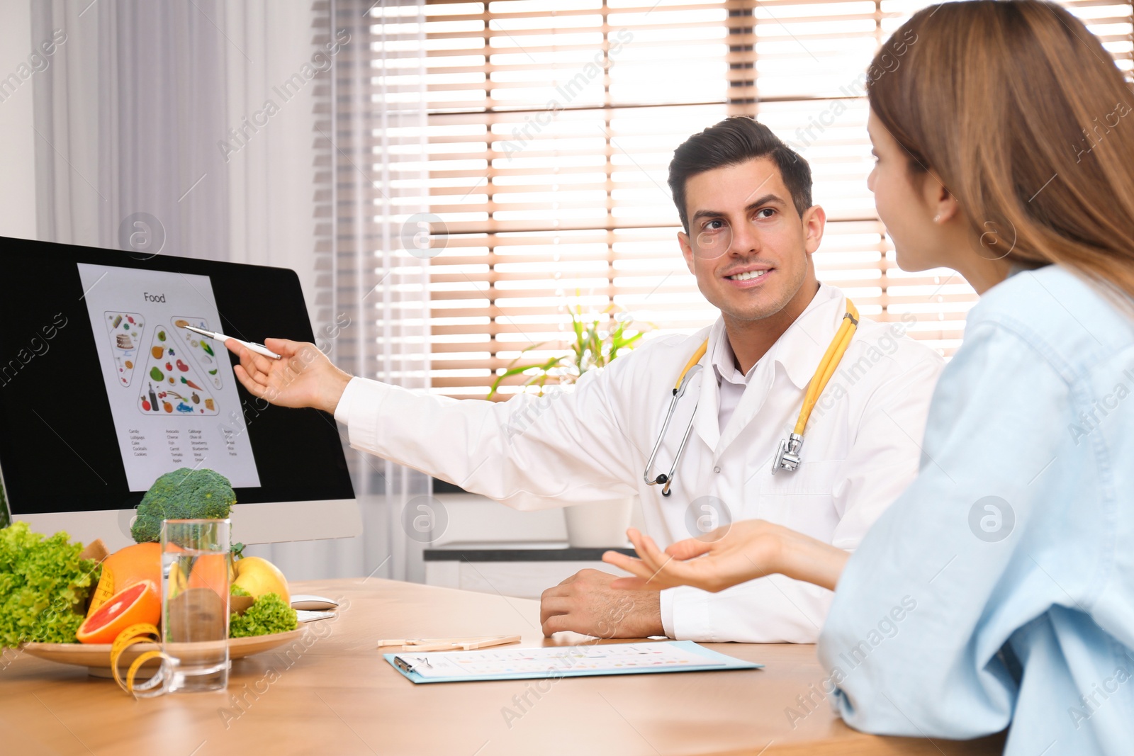 Photo of Nutritionist consulting patient at table in clinic