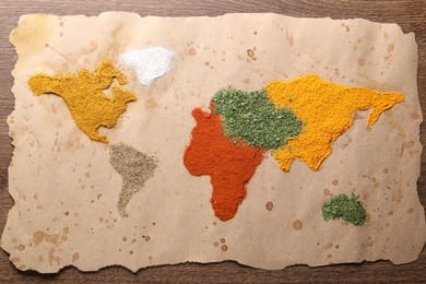 Photo of World map of different spices on wooden table, top view