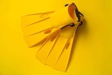 Photo of Pair of flippers on yellow background, flat lay