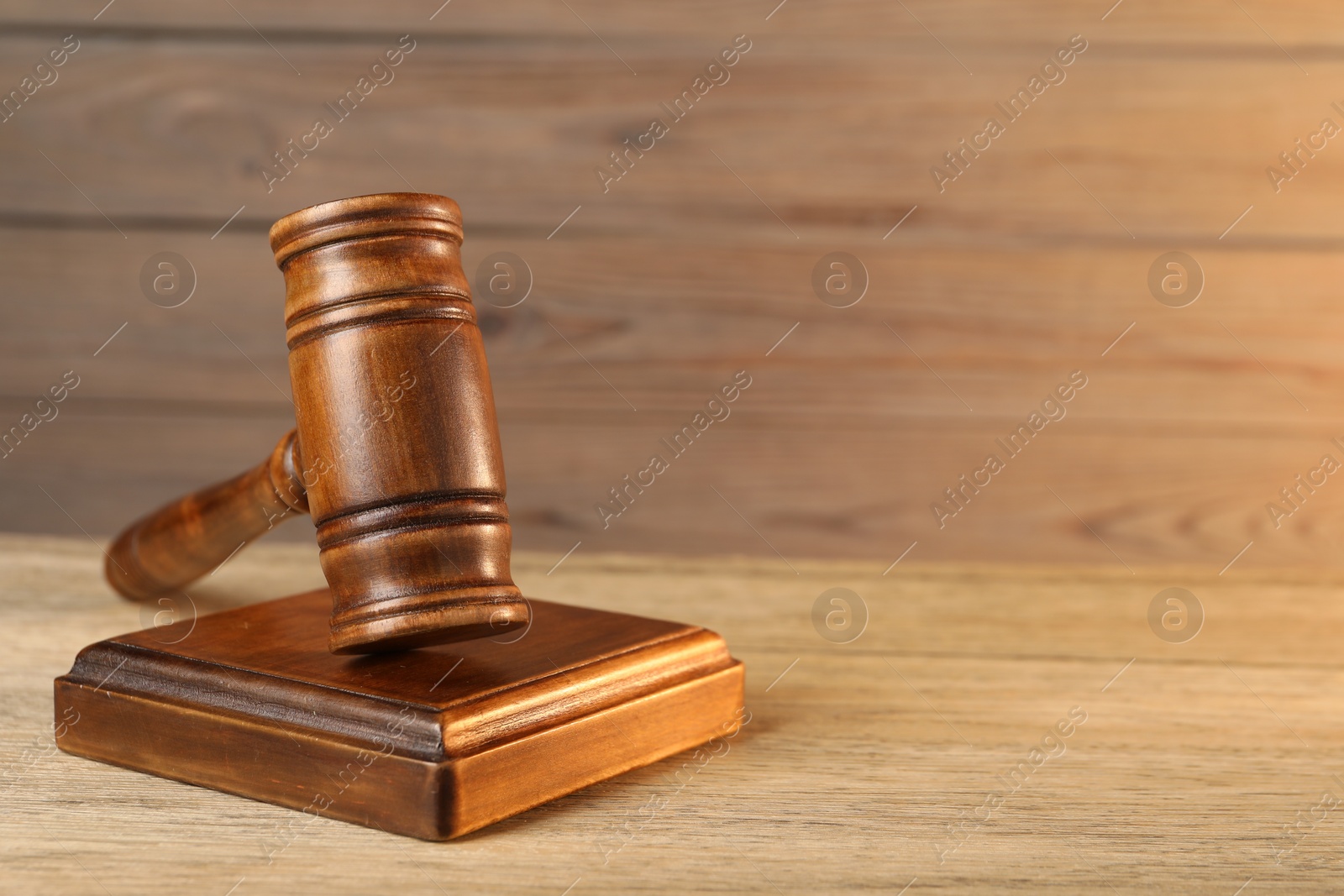 Photo of Wooden gavel and sound block on table, closeup. Space for text