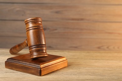 Wooden gavel and sound block on table, closeup. Space for text