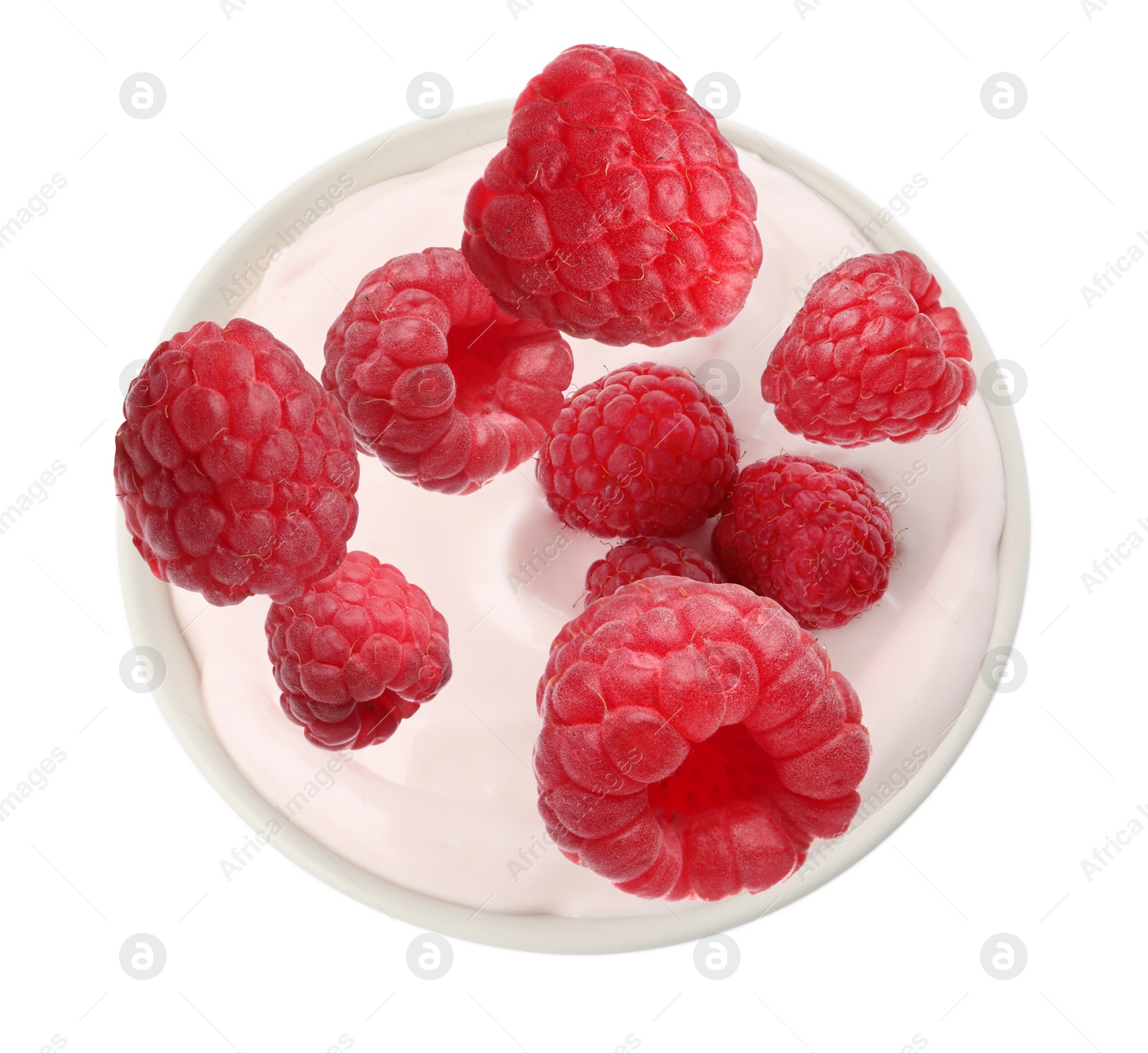 Image of Delicious ripe raspberries falling into bowl with yogurt on white background, top view