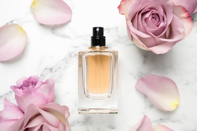 Photo of Flat lay composition with bottleperfume and roses on white marble background