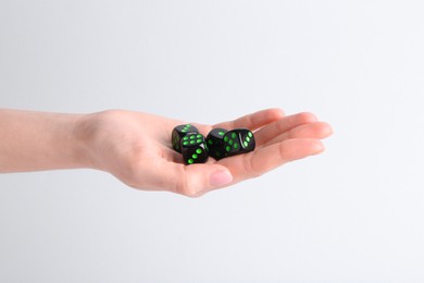Photo of Woman holding game dices in hand on white background, closeup