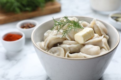 Tasty dumplings in bowl served on white table, closeup