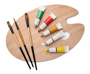 Photo of Wooden palette with oil paints and brushes on white background, top view