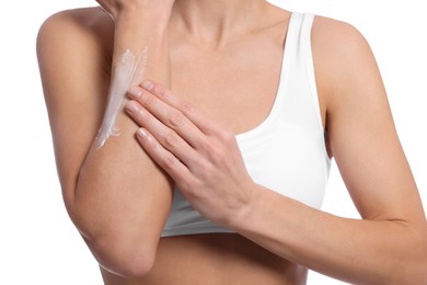 Photo of Woman applying body cream onto her arm against white background, closeup
