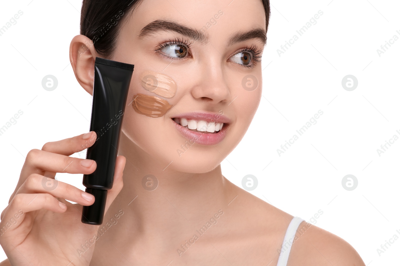 Photo of Teenage girl holding tube of foundation on white background