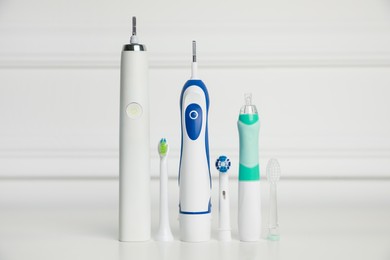 Photo of Electric toothbrushes and replacement brush heads on light background