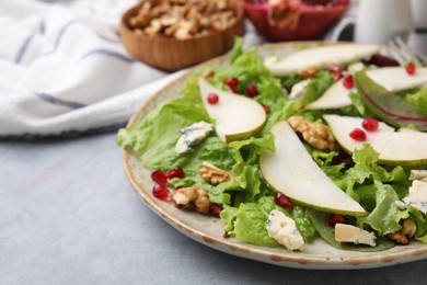 Photo of Delicious pear salad on grey textured table, closeup. Space for text