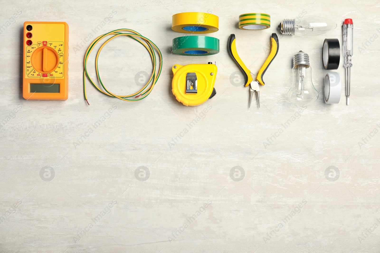 Photo of Electrician's tools and space for text on light background, flat lay